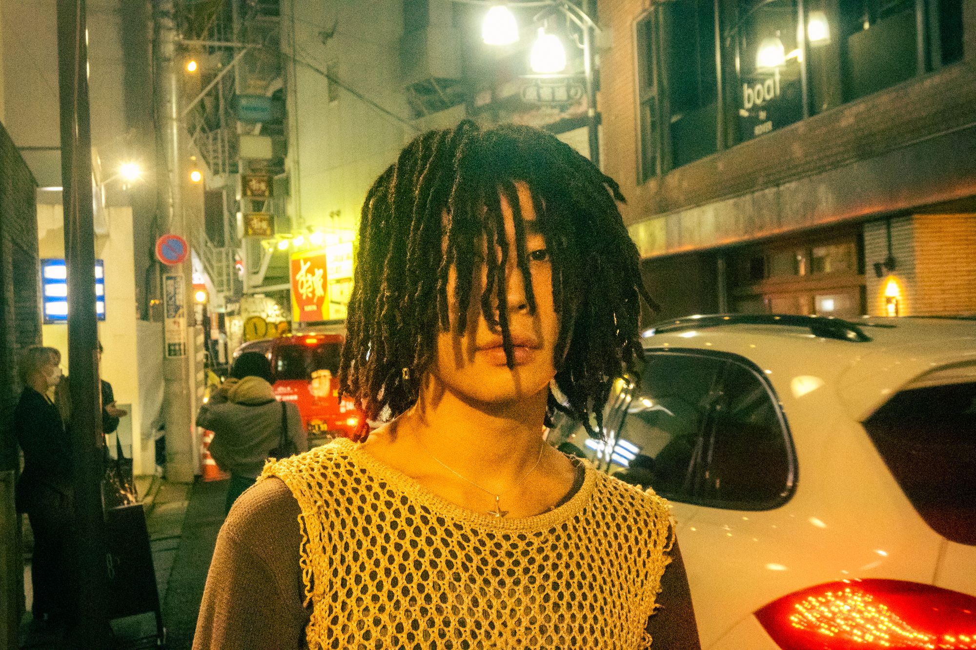 A Japanese man appropriating dreadlocks from Black popular for visual aesthetics. 