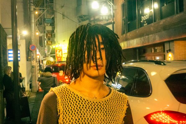 A Japanese man appropriating dreadlocks from Black popular for visual aesthetics. 